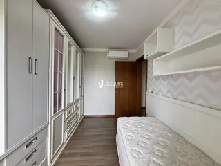 Quarto com armários embutidos e cabeceira em um ambiente interno.