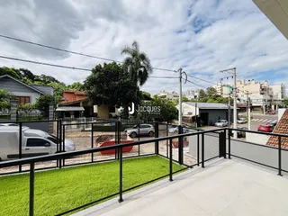Vista externa de uma propriedade com cerca de metal e gramado.