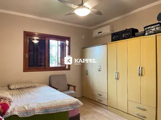 Quarto com cama e armários de madeira em ambiente interno.