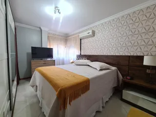 Quarto com cama e televisão em um imóvel no Brasil.
