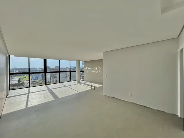 Sala ampla com grande janela oferecendo vista para a paisagem.
