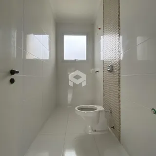 Foto do interior de um banheiro com revestimento cerâmico branco.