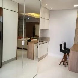 Interior de um ambiente com paredes brancas e armários brancos.