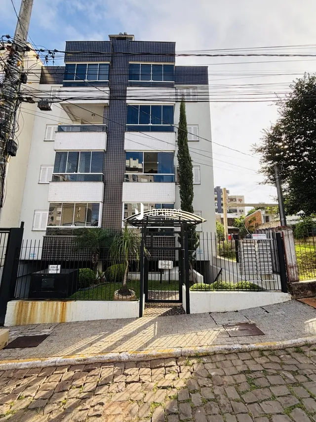 Fachada de um prédio residencial em Lajeado, Brasil, com cerca e portão de entrada.