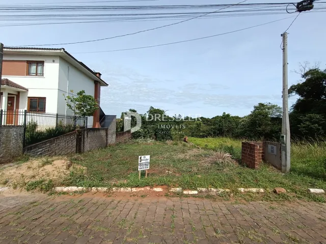 Vista da fachada de uma residência em Lajeado, Brasil, com cerca e vegetação ao redor.