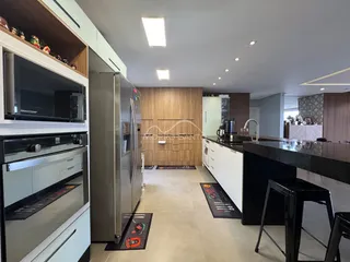 Cozinha moderna com armários de madeira e eletrodomésticos de aço inoxidável.