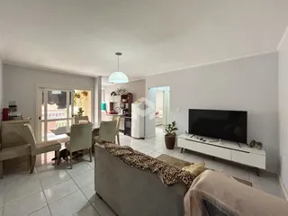 Sala de estar com área de jantar e cozinha.