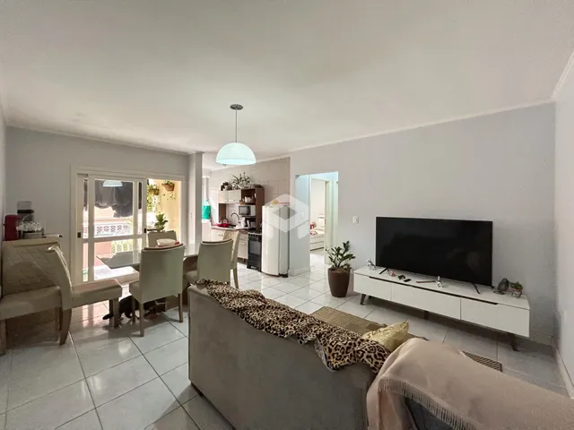 Sala de estar com área de jantar e cozinha.
