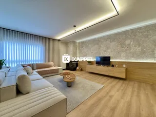 Sala de estar moderna com sofá grande e piso de madeira clara.
