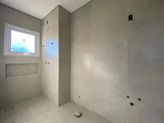 Foto de um cômodo interno com paredes cinzas e uma janela.