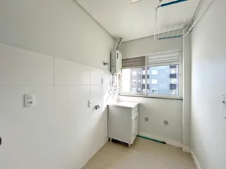 Hall de entrada com paredes brancas e janela em um imóvel no Brasil.