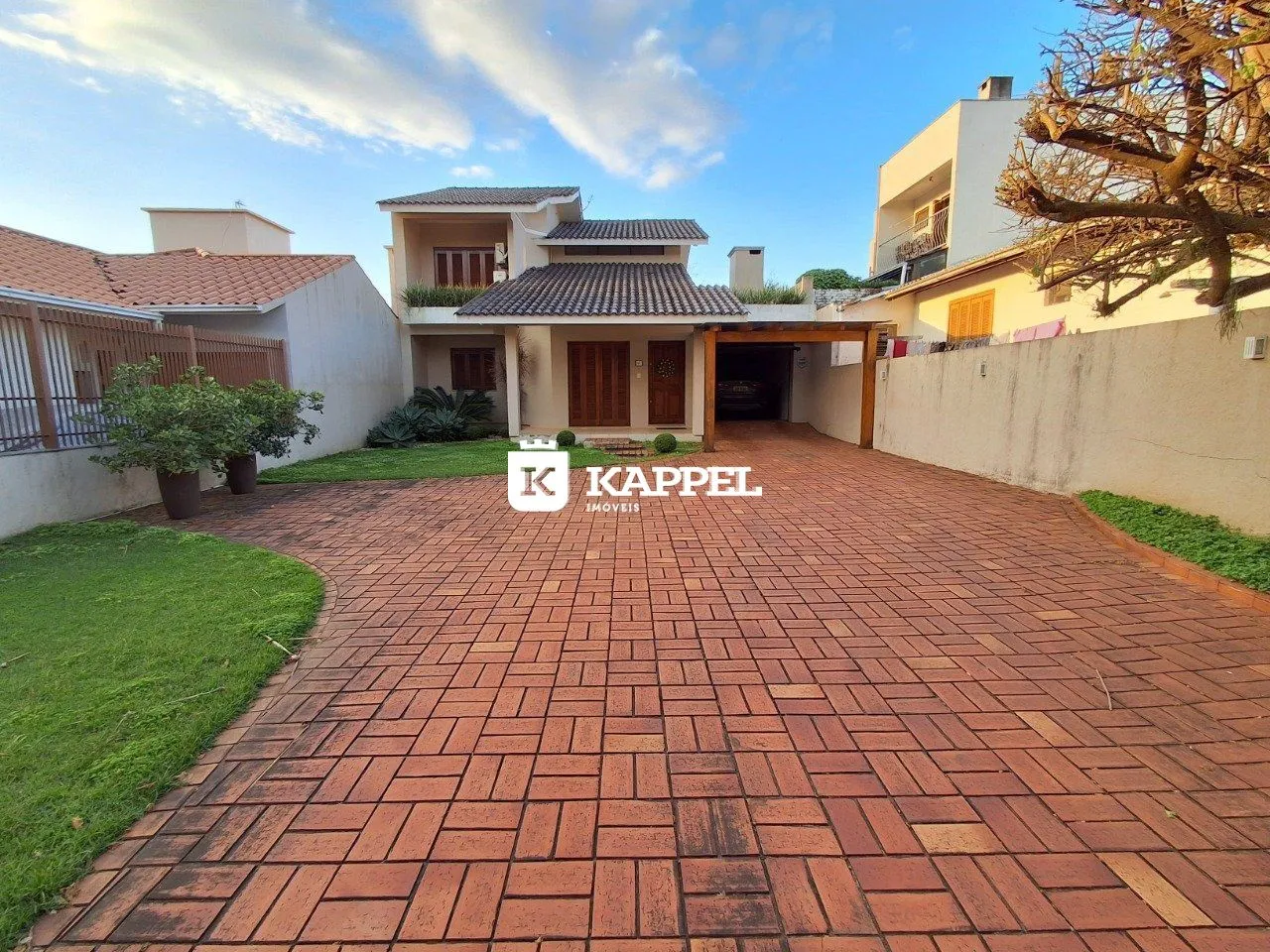 Fachada de uma residência em Lajeado, Brasil, mostrando a entrada e o pátio pavimentado.