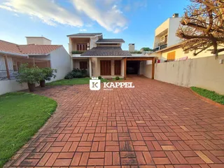 Fachada de uma residência em Lajeado, Brasil, mostrando a entrada e o pátio pavimentado.