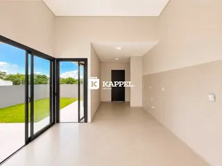 Hall de entrada com piso claro e portas de vidro que dão para o exterior.