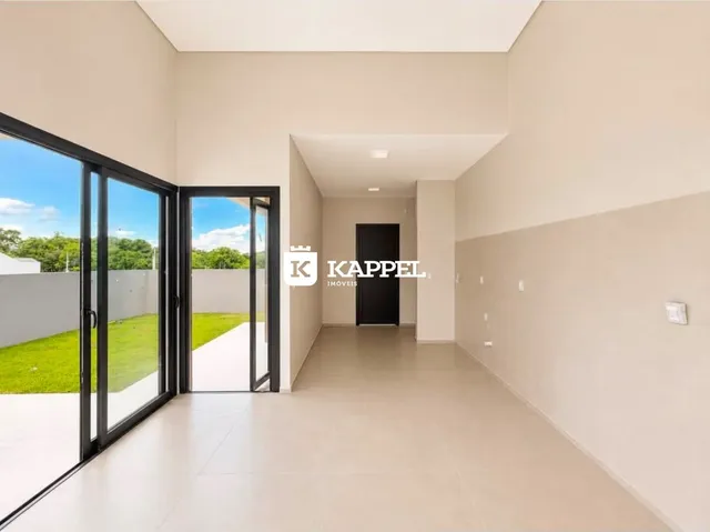 Hall de entrada com piso claro e portas de vidro que dão para o exterior.