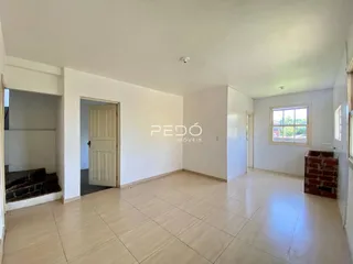 Ambiente interno de uma sala com piso de cerâmica e paredes brancas.