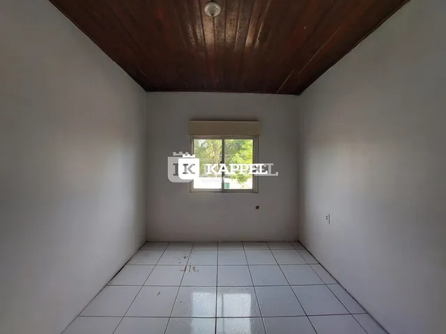 Ambiente interno de um cômodo com piso de cerâmica e teto de madeira.
