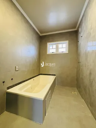 Foto de um banheiro com banheira e janela em um imóvel.
