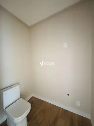 Foto de um ambiente interno mostrando um vaso sanitário e piso de madeira.