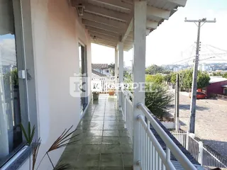 Passagem coberta externa de uma residência em Lajeado com grade branca.
