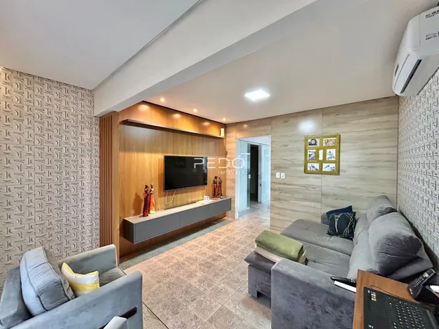 Sala de estar moderna com sofá e painel de madeira.