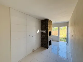 Corredor interno com piso de cerâmica e parede de destaque em pedra.