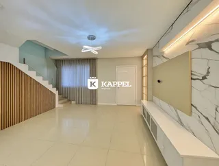 Ambiente interno com piso claro e escadaria em um imóvel.