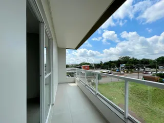 Vista de uma sala com acesso a uma varanda com vista para a paisagem.