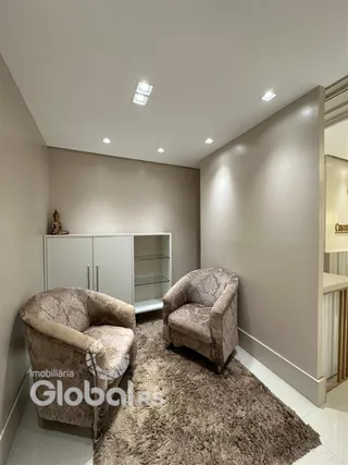 Sala de estar com duas poltronas e tapete.