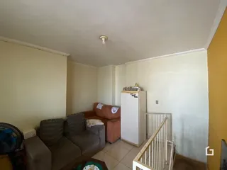 Sala de estar com sofá e móveis em ambiente interno.