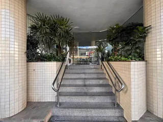 Hall de entrada com escadaria e vegetação.
