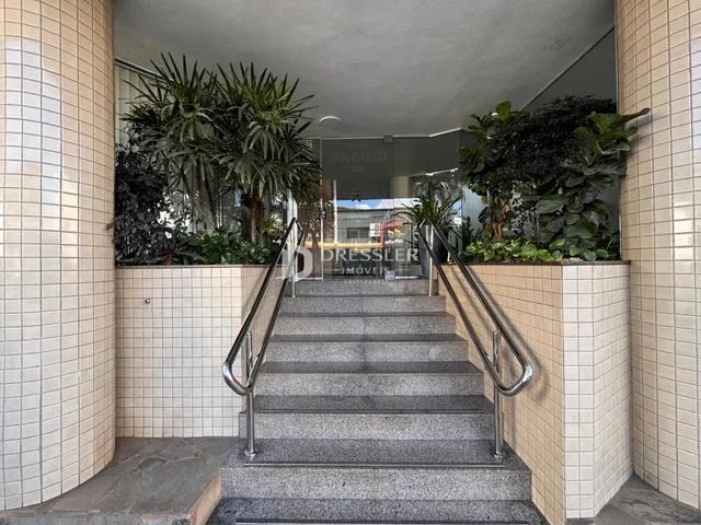 Hall de entrada com escadaria e vegetação.