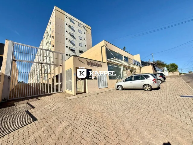 Vista externa de um prédio comercial em Lajeado, Brasil, com acesso por portão e estacionamento.