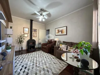 Sala de estar com lareira e piso de madeira no interior da residência.