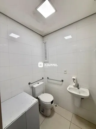Banheiro com revestimento branco e louças sanitárias instaladas.