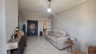 Sala de estar com sofá e piso de cerâmica em uma residência.