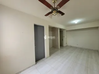 Uma sala de estar com piso de cerâmica clara e paredes brancas.