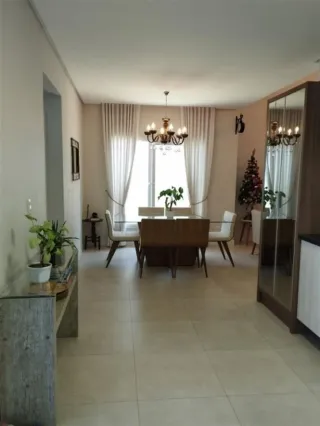 Uma sala de jantar com mesa e cadeiras em um imóvel em Lajeado.