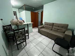 Sala de estar com sofá e mesa de jantar em um apartamento em Lajeado.