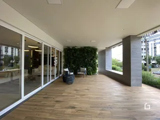 Sala com piso de madeira e grandes janelas de vidro.
