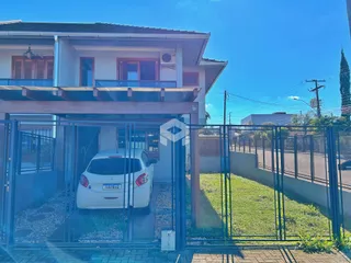Fachada de uma casa em Lajeado, Brasil, com portão de ferro e gramado.