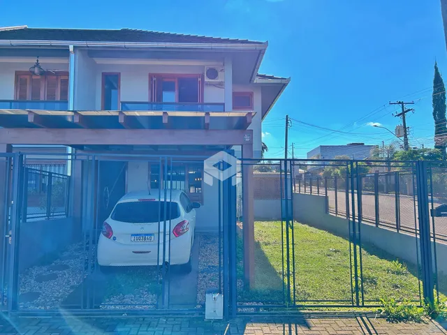 Fachada de uma casa em Lajeado, Brasil, com portão de ferro e gramado.