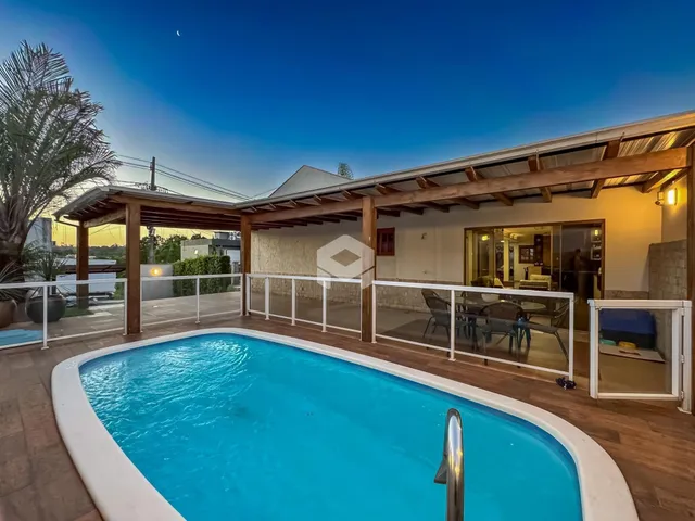 Vista da piscina externa com deck e estrutura de madeira em Lajeado.