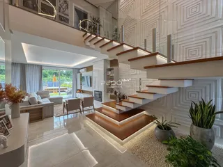Sala de estar moderna com escadaria de vidro e grandes janelas.