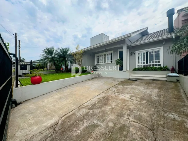 Fachada de uma residência em Lajeado, Brasil, com jardim e entrada de concreto.