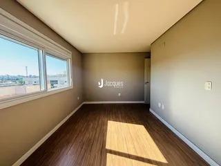 Sala de estar com piso de madeira e grande janela com vista para a cidade.