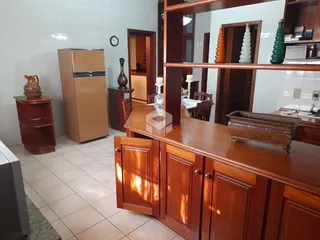Interior de uma cozinha com armários de madeira e piso de cerâmica.