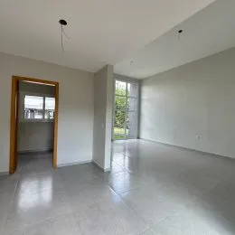 Hall de entrada com piso claro e paredes brancas.