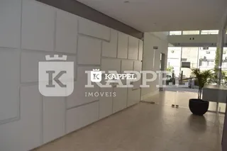 Vista interna de um corredor com paredes brancas e piso claro.