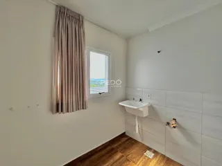Foto de um banheiro com piso de madeira e bancada branca.